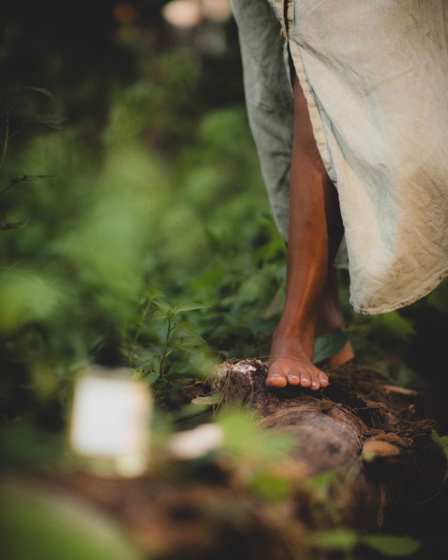 Un picior desculț așezat pe o rădăcină, în iarbă