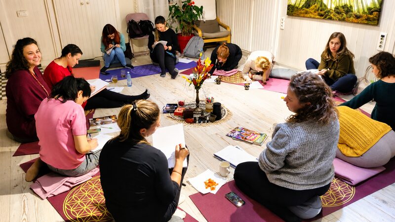 Women seated in a circle, writing and reflecting together