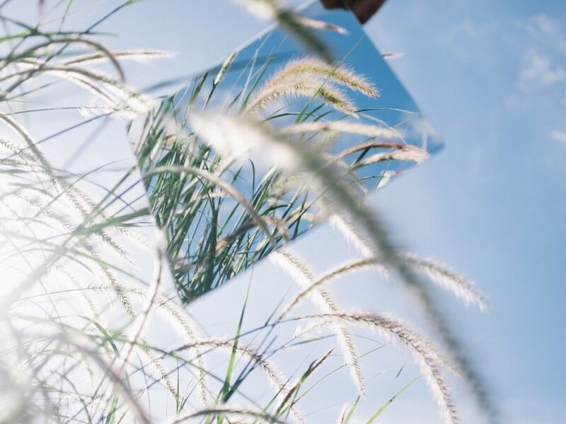 A mirror reflecting the sky and grasses